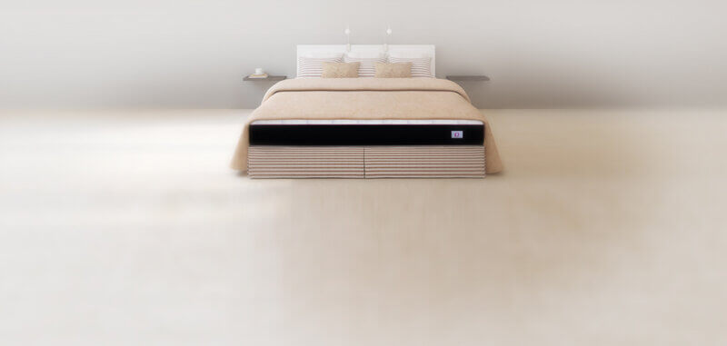 Omni Mattress in a bed with beige duvet